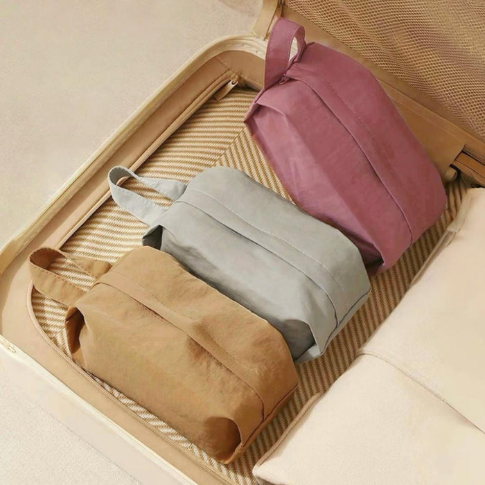 Soft Hue organizer bags in suitcase: mauve, grey and tan zip pouches with top handles for travel packing.