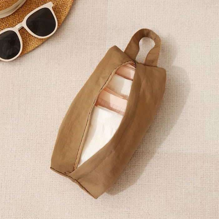 Tan Soft Hue organizer bag partly unzipped showing toiletry bottles; top-handle zip pouch for bathroom or travel.