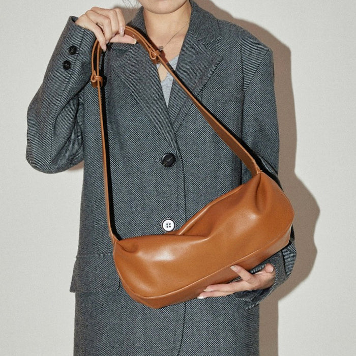 Model carrying a tan Soft Leather Baguette Bag handheld, ideal for city walks and gifting.