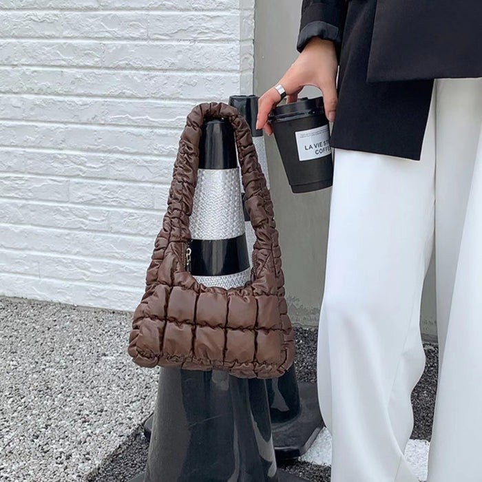 Model carrying a brown Soft Leather Puffer Shoulder Bag handheld, ideal for city walks and gifting.
