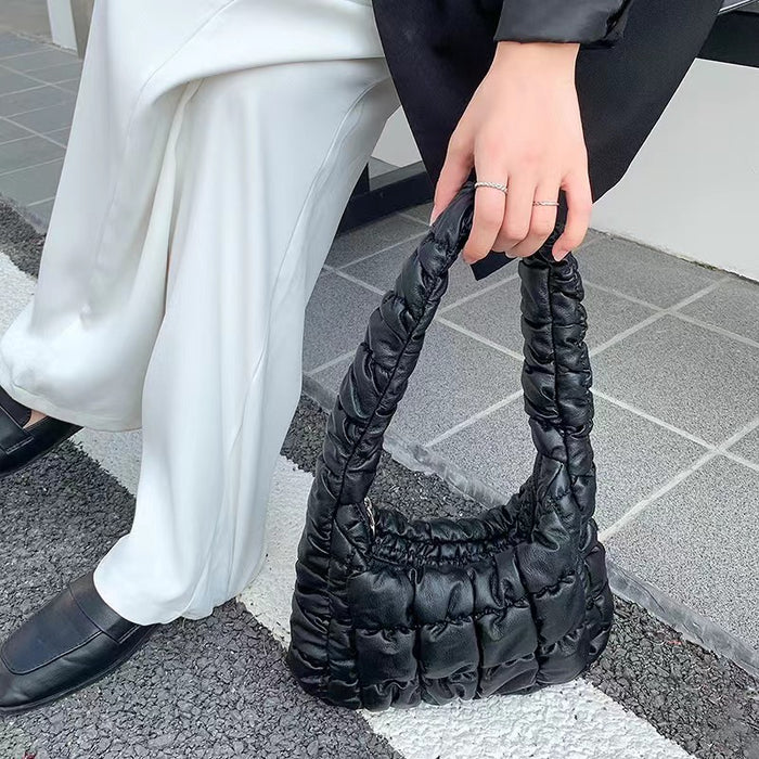 Model holding a Soft Leather Puffer Shoulder Bag in black, ideal for errands and gifting.