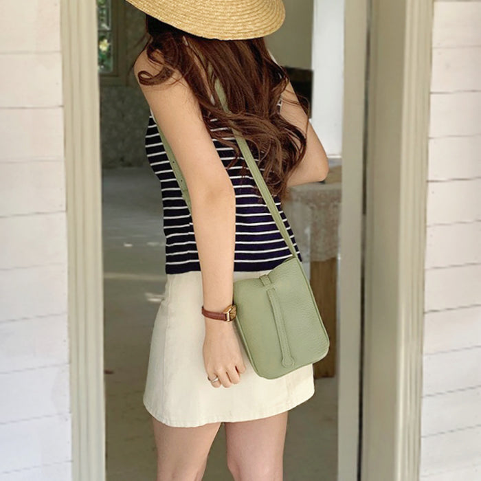 Model carrying the green leather bag with a casual-chic outfit.
