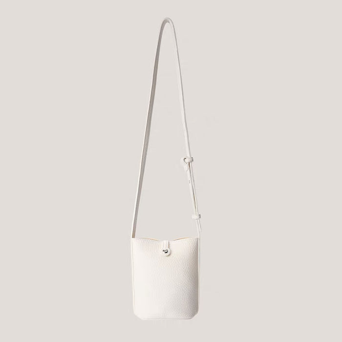 White lychee leather crossbody bag with a metallic designer buckle on clean background.