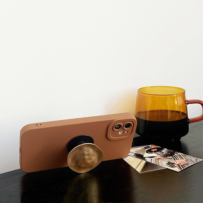 Side view of brown phone case using metallic kickstand for hands-free viewing.