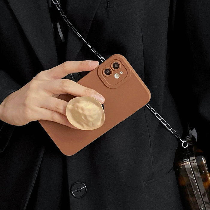 Model holding brown Solid Color Case. Showcasing a minimalist matte finish and integrated stand.