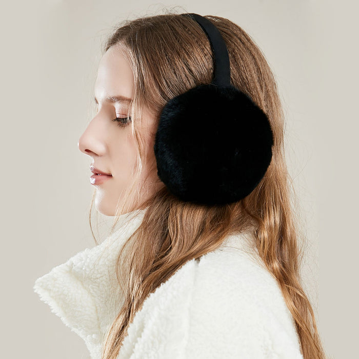 Side view of model wearing black plush earmuffs; sleek minimalist winter ear protection.