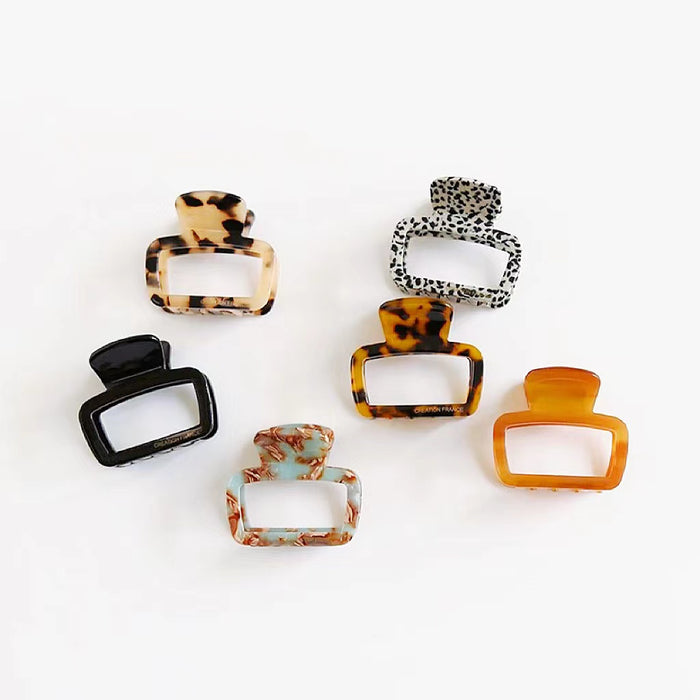 Six colors of square hair claws placed on a clean background, showcasing the minimalist geometric design.