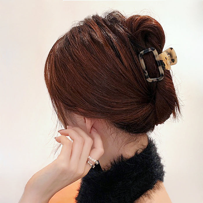 Model with a full updo secured by a light leopard square claw, ideal for thick hair during formal dinners.