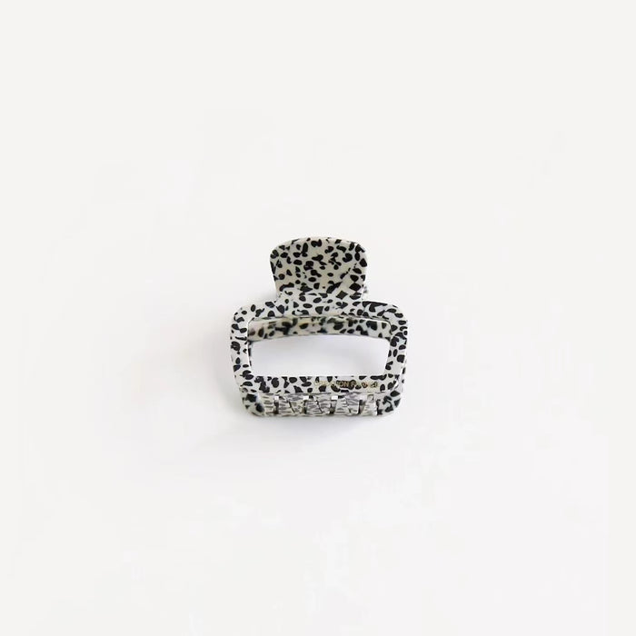 Black and white dots print square hair clip on clean background, trendy graphic pattern for street style accents.