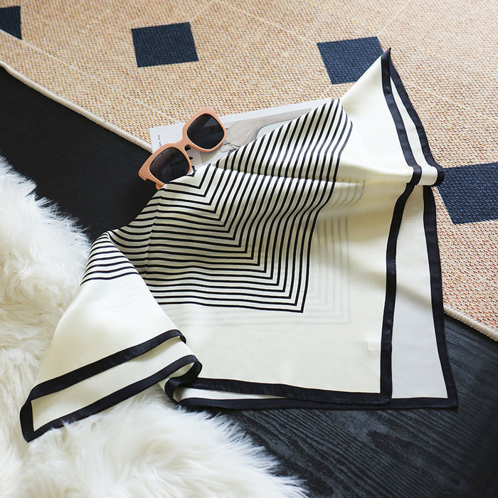 The geometric pattern silk scarf folded to show the contrast of stripes.