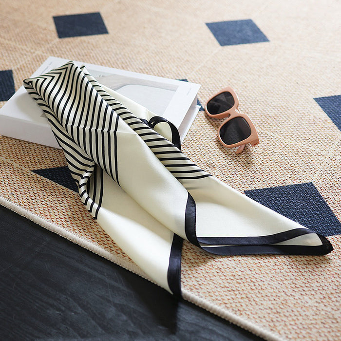 Close-up of the square silk scarf showing the delicate texture and print.