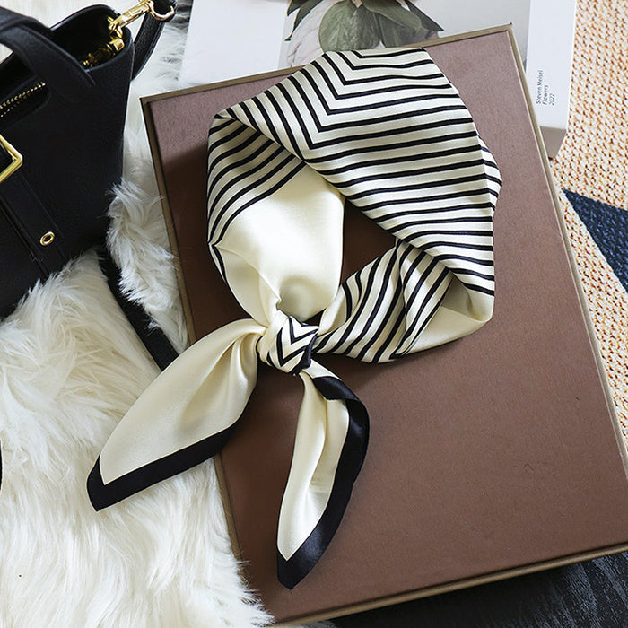 The square pattern silk scarf knotted elegantly on a display box.