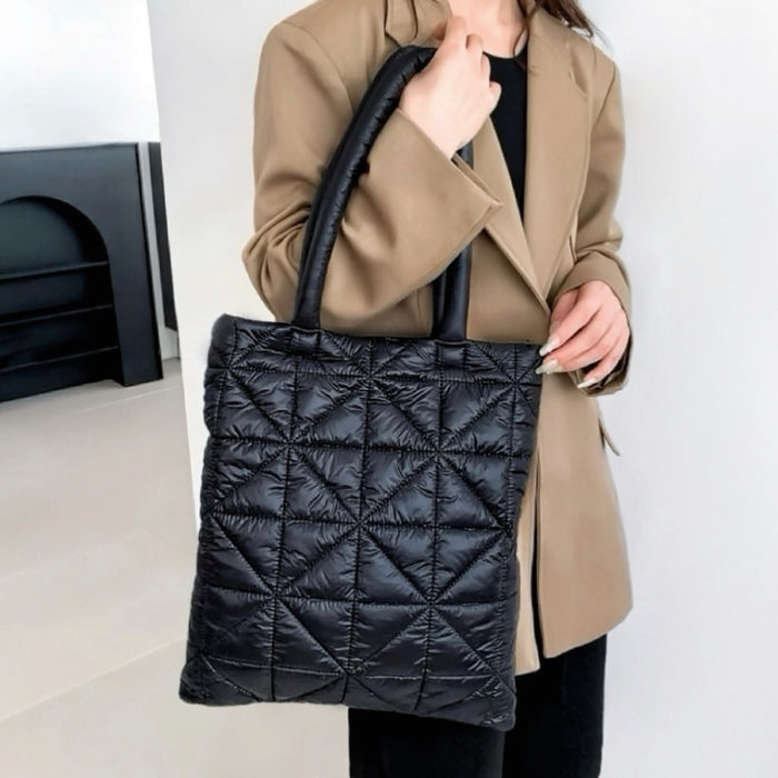 Model carrying a black polyester shoulder bag handheld, easy for commuting and weekends.