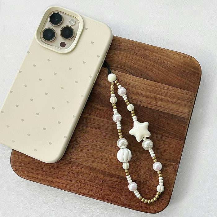 Angled view of a phone case with Starry Pearl Delight Phone Charm, easy to attach to bags and phones.