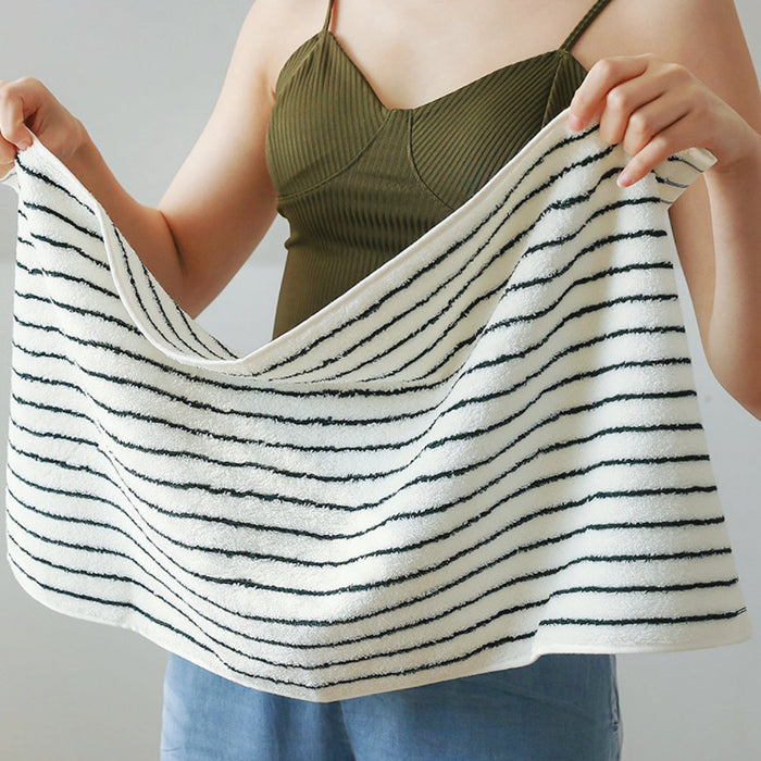 Model holding a striped face towel in hand.