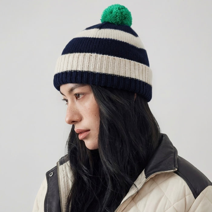Mode wearing a navy and white striped beanie with a green pompom.
