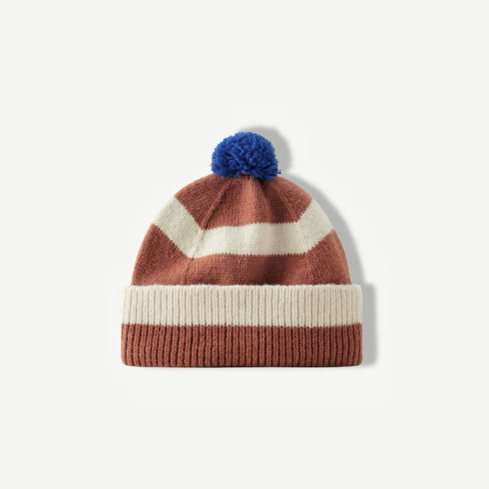 Brown and white striped beanie with a blue pompom on a white background.