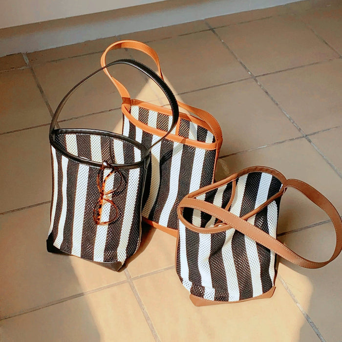 Front view of Three stripe woven bucket bags with PU leather trim and raffia straw.