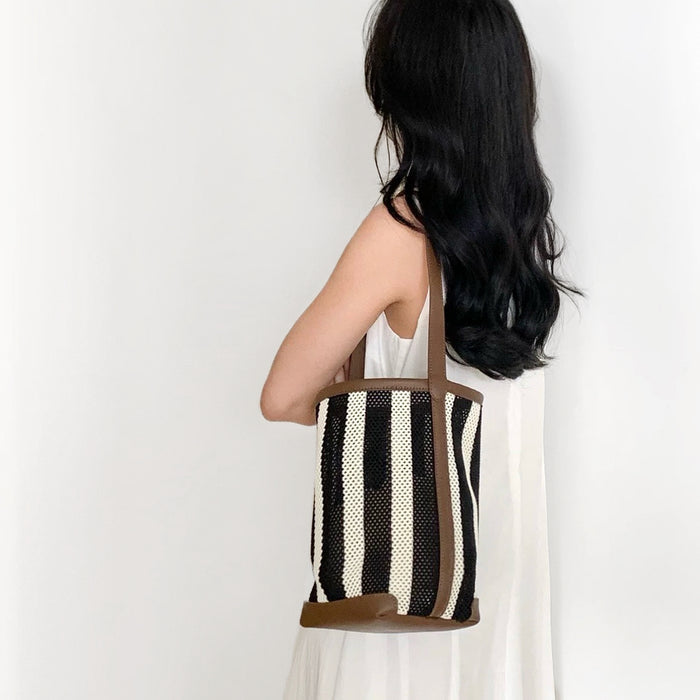 Model carrying a Stripe Woven Bucket Bag on shoulder, ideal for city walks and gifting.