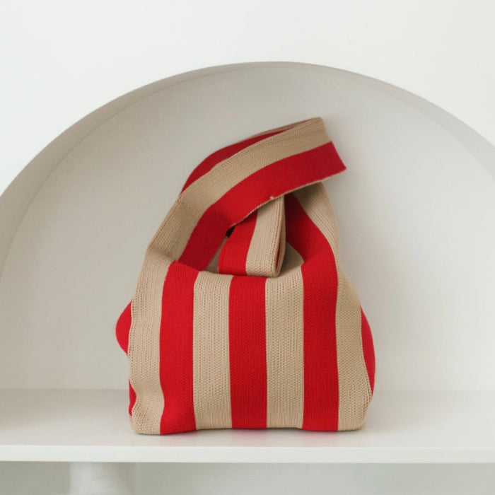 Close-up of a retro red and khaki stripe knitted bag, showing the tactile woven texture and integrated handle.