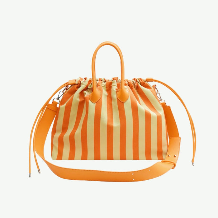 Flat lay of the orange and white striped bowling bag; vibrant colorway perfect for summer Street Style accents.