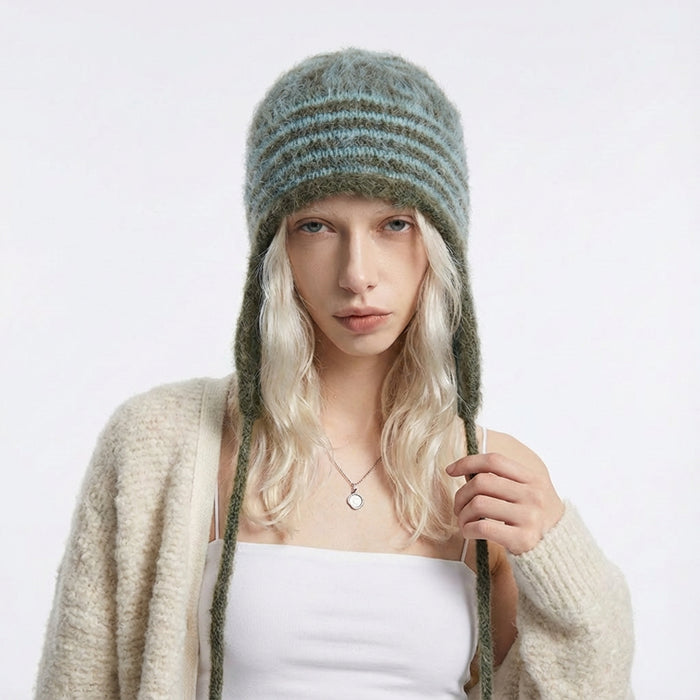 Model wearing the peacock green and olive green striped earflap hat.