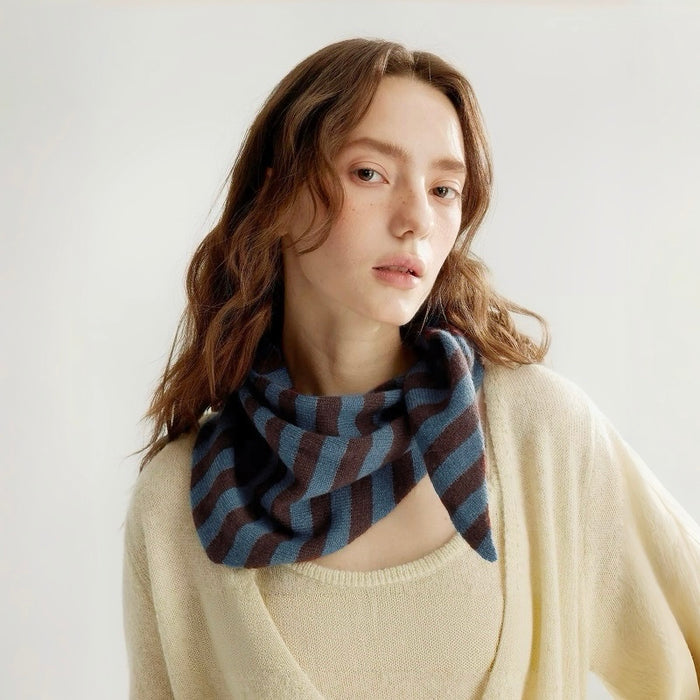 Model wearing the blue and brown striped triangle scarf in gray, great for office layering and commuting.