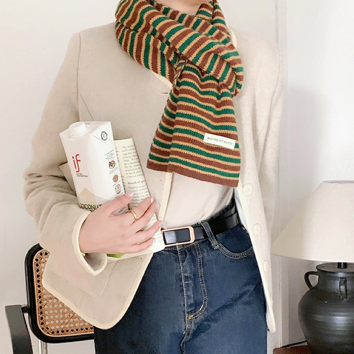Model wearing Knitted striped scarf in brown, green, and beige, made of acrylic and cotton.