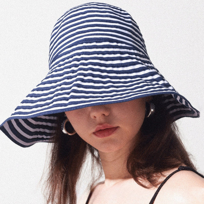 Navy and white striped cotton wide brim bucket hat with a smart dual-brim design for beach outings.