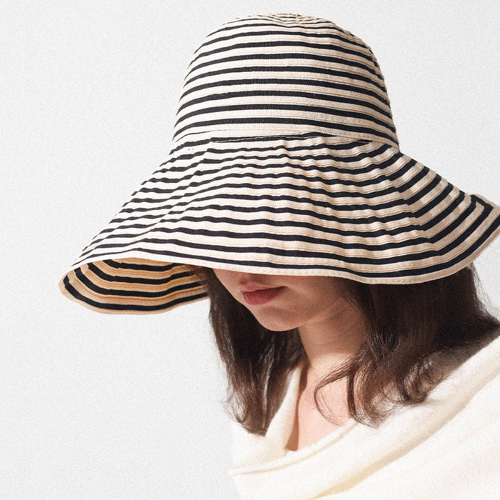 Model wearing Striped Wide Brim Bucket Hat in khaki black, highlighting the classic horizontal stripes.