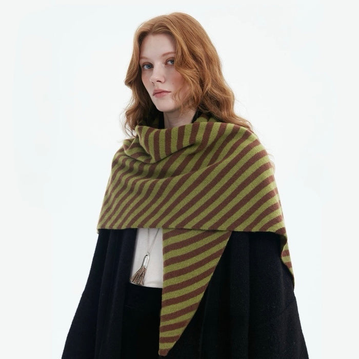 Side view of the model wearing the green striped wool triangle scarf as a shawl over her shoulder.
