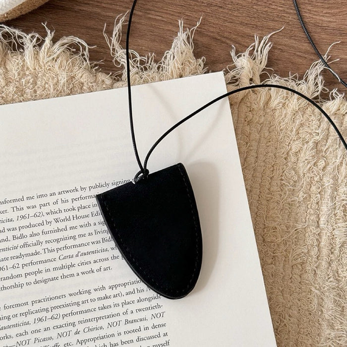 Folded view of Suede Arrow Eyeglass Holder Necklace in Black, easy to style.
