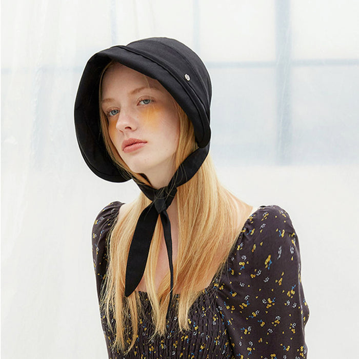 Front view of a model wearing the black ribbon bucket hat with streamers tied.