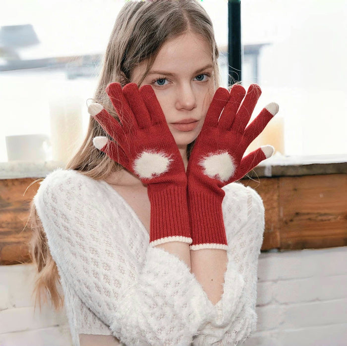 Close-up sweetheart knitted gloves with heart pattern and ribbed cuff; cozy knit for cold days.