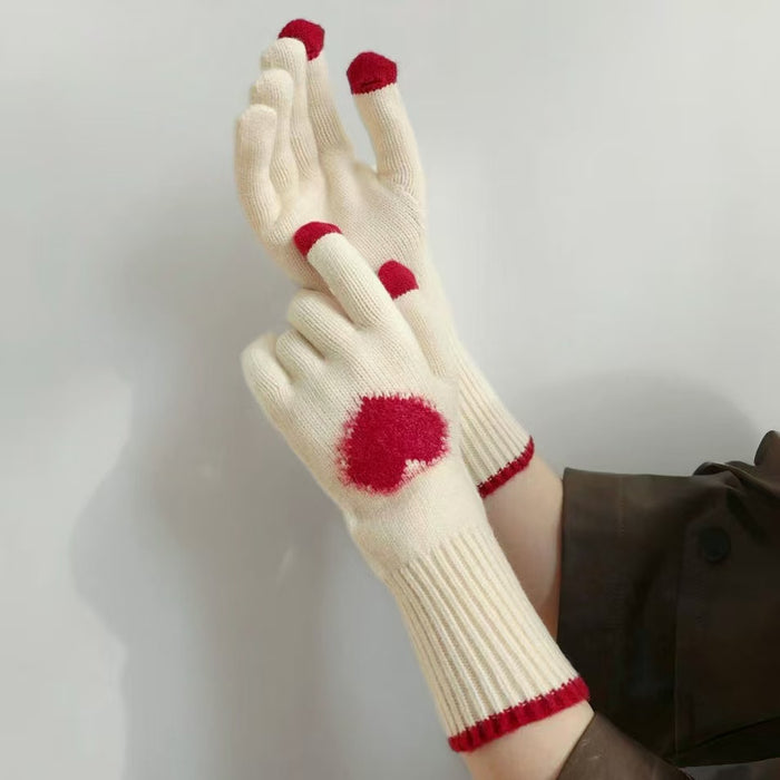 Model wearing sweetheart knitted gloves; heart motif knit for cozy cold-weather styling.