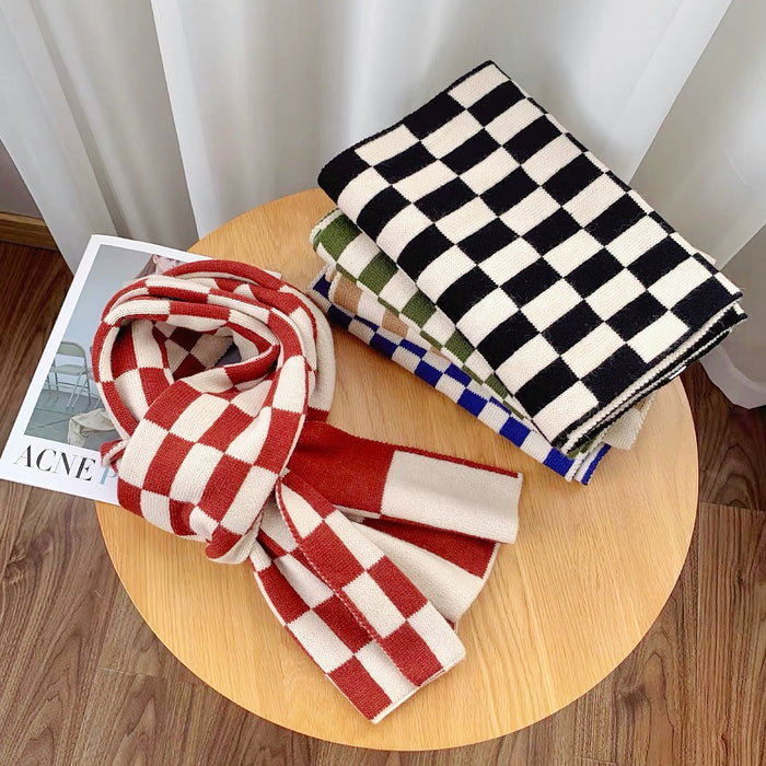 Front view of Thick wool checkered scarves in red/white, black/white, green/white, and blue/white, folded on a wooden.