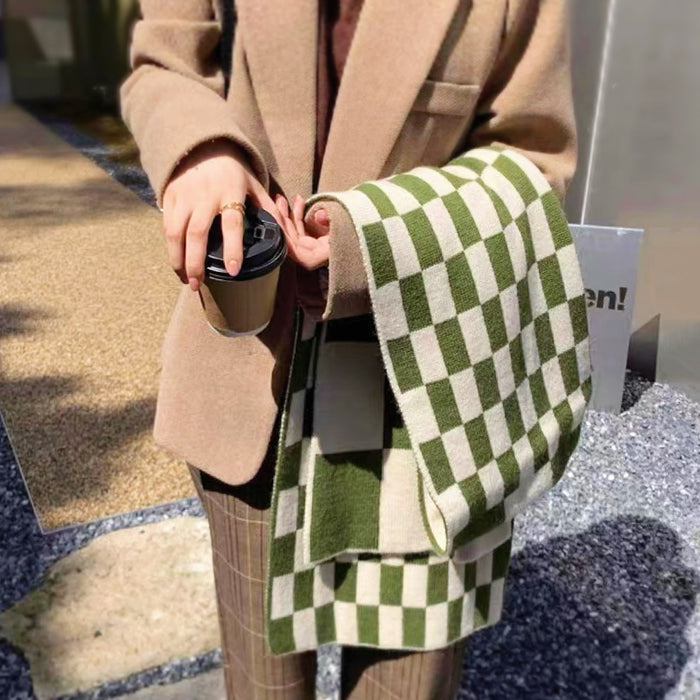 Model wearing a plaid wool scarf in green, great for office layering and commuting.