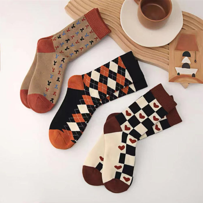 Angled view of Three pairs of retro cotton-acrylic socks with unique patterns: hearts, argyle and grass.