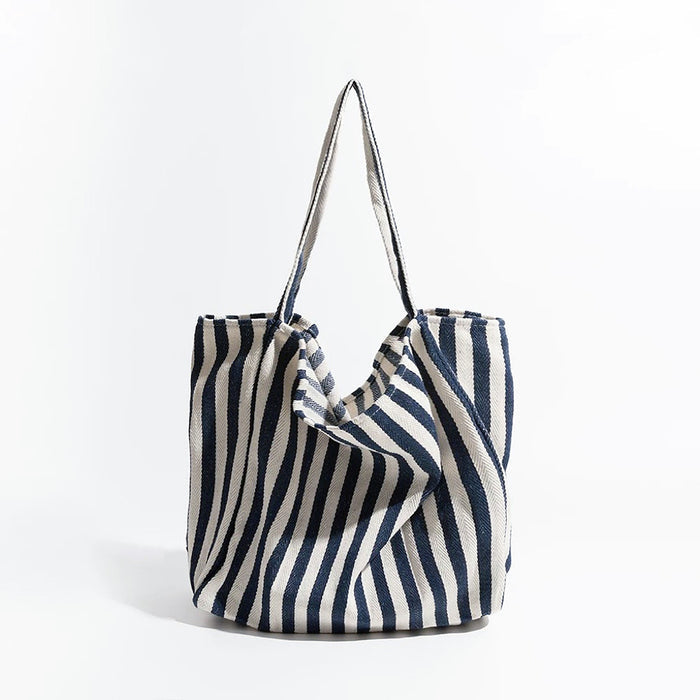Front view of navy blue and white striped canvas tote, classic nautical look suited for outdoor picnics and boat trips.