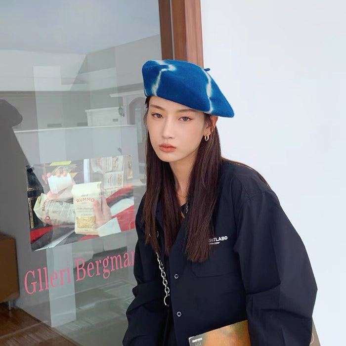 Model wearing the blue and white tie-dye wool beret for a modern look.