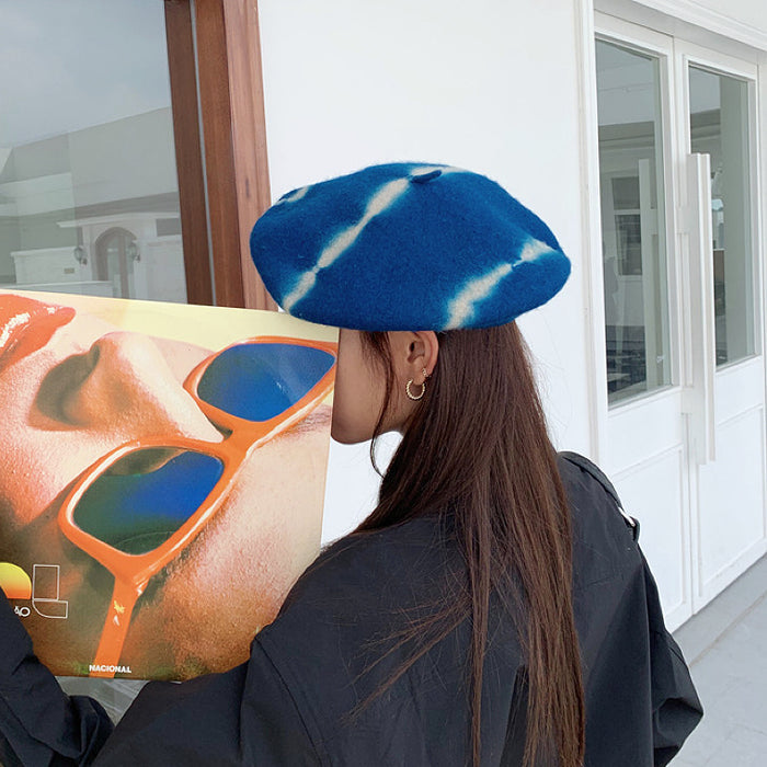 Side view of the blue tie-dye beret highlighting the unique pattern distribution.
