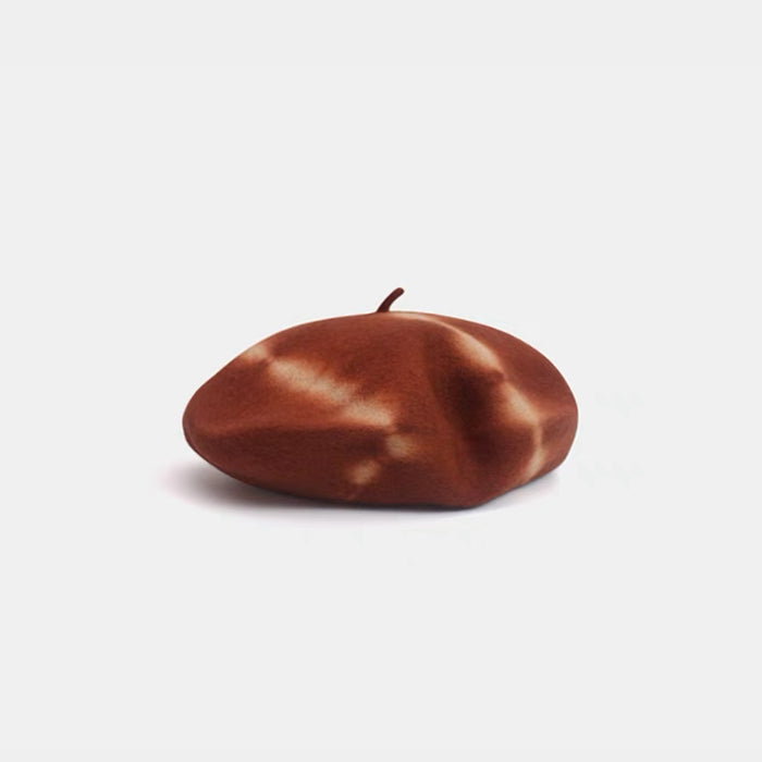 Brick red and beige tie-dye wool beret displayed on a white background.