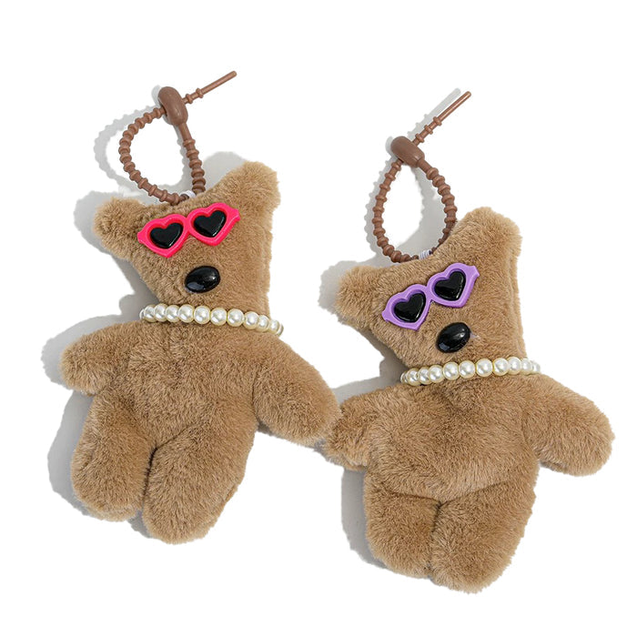 Flat lay of ttwo colors of Tilted Sunglasses Bear Bag Charms, great for everyday styling and gifting.