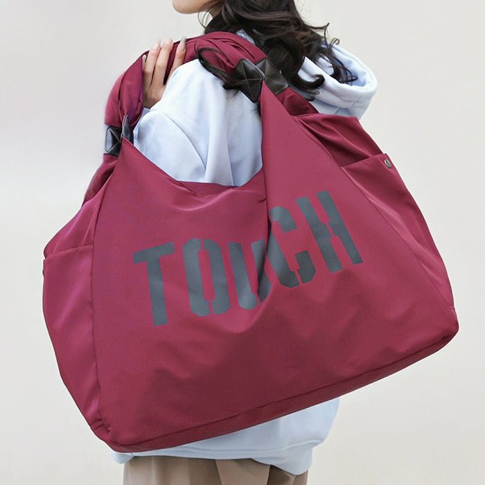 Model carrying a  Touch Nylon Weekend Bag in claret, ideal for errands and gifting.