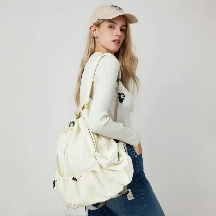 Side view of model with white backpack; adjustable straps offer comfortable hands-free carry for city walks.
