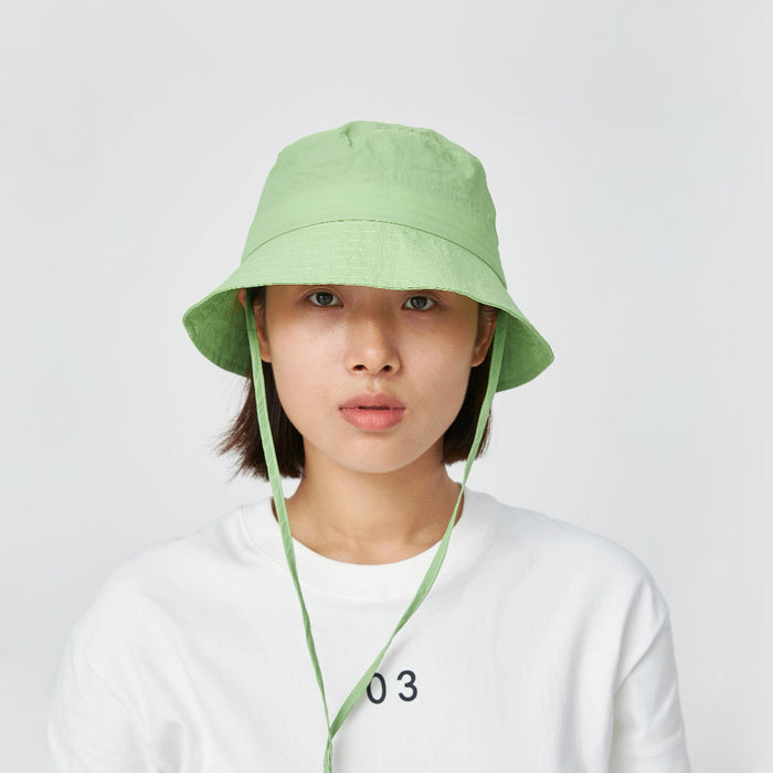 Model wearing fresh green Ultralight Quick Dry Bucket Hat, designed for peak performance and sun protection outdoors.