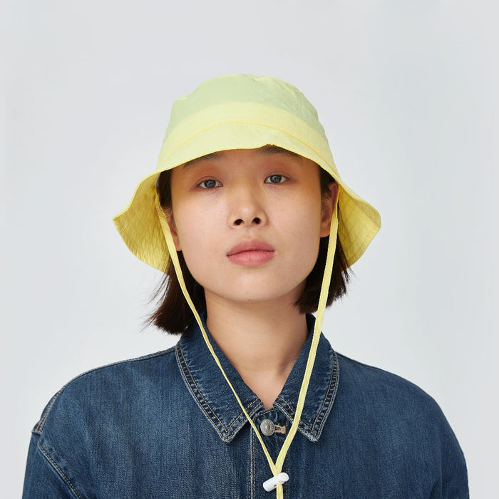 Model wearing cream yellow Ultralight Quick Dry Bucket Hat. Features lightweight tech nylon for rapid drying.