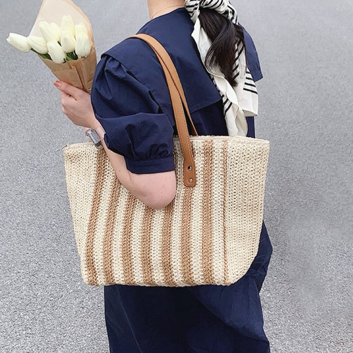 Model carrying a Vertical Striped Straw Tote Bag in khaki, ideal for city walks and gifting.