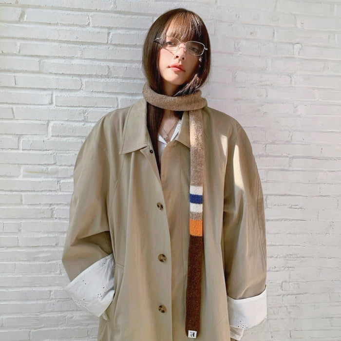 Model wearing a polyester scarf in beige and khaki and brown, easy for weekend styling and gifting.