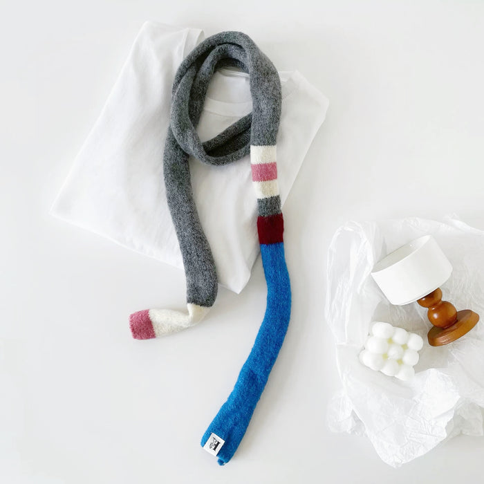 Close-up of Vibrant Colorblocked Skinny Scarf in gray and blue, easy for travel packing and gifting.